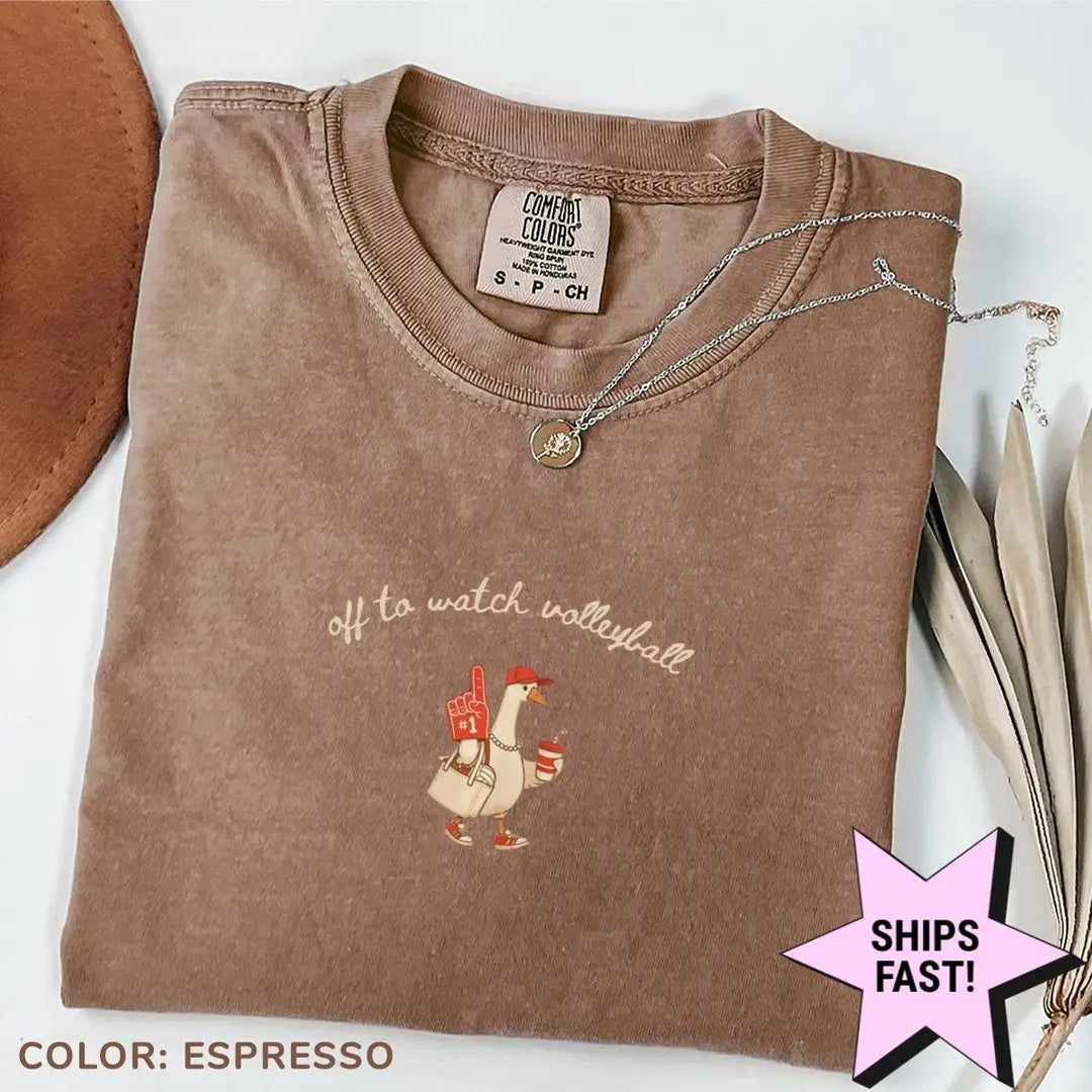 Folded Espresso brown Comfort Colors tee with the volleyball goose design, showing the neck label and ribbed collar
