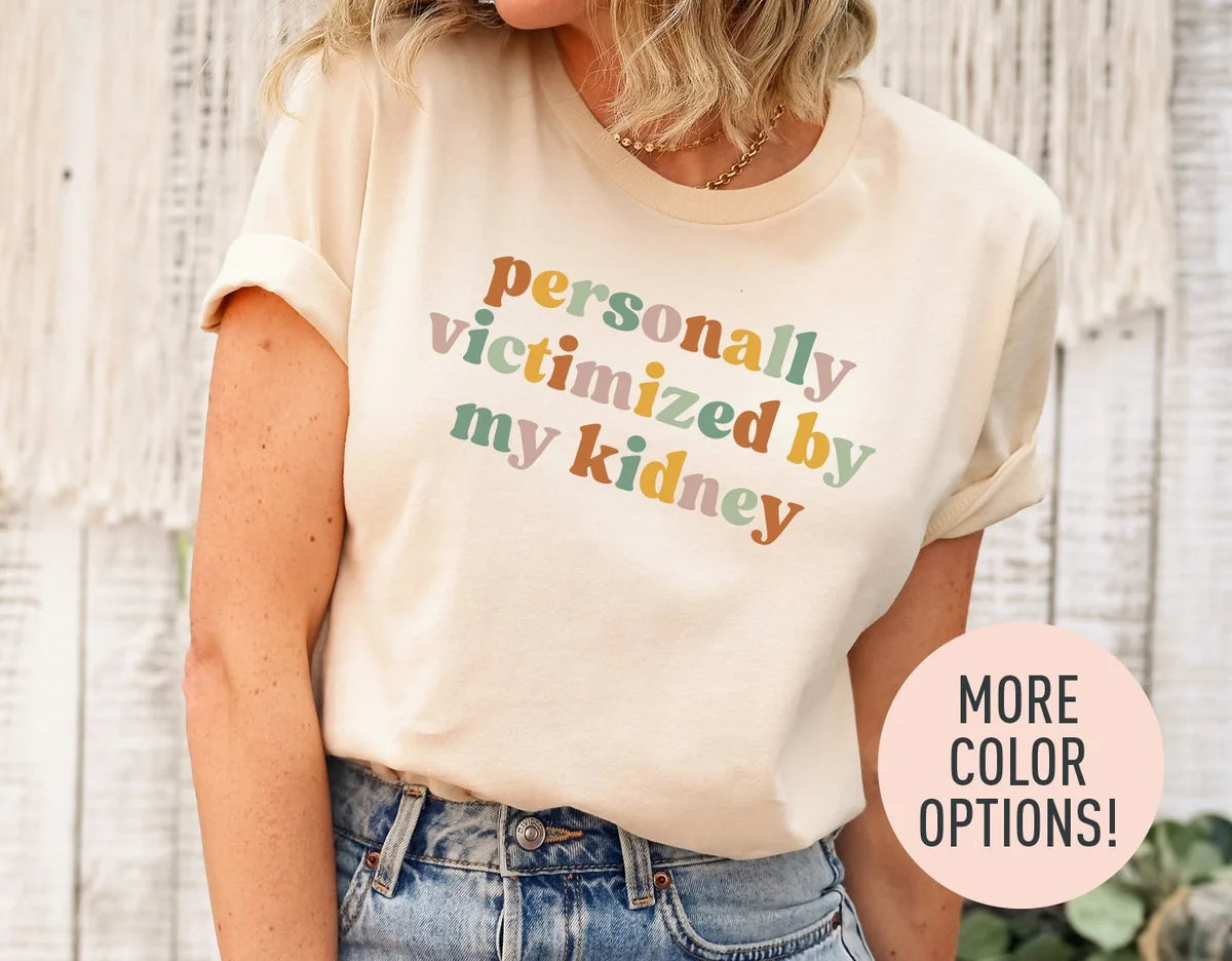 Woman in a natural cream tee with rolled sleeves and jeans, personally victimized by my kidney in rust, sage and rose