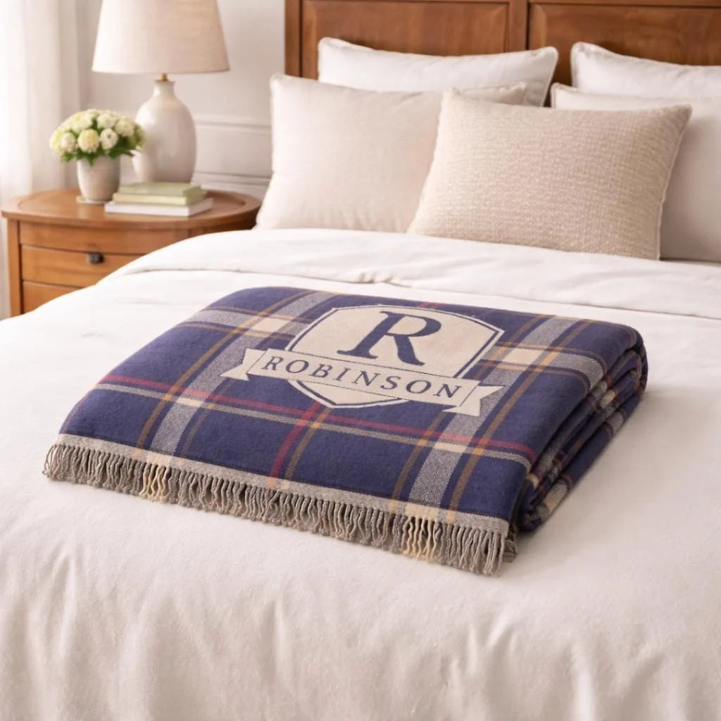 Close-up of the personalized plaid crest woven blanket with texture and fringe detail