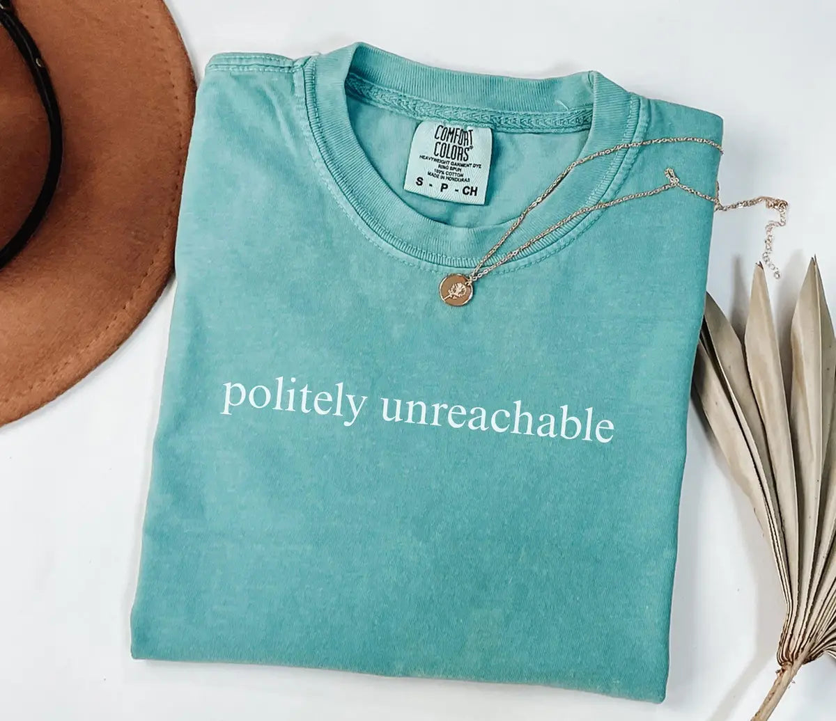 Seafoam Comfort Colors T-shirt with the words Politely Unreachable in white.