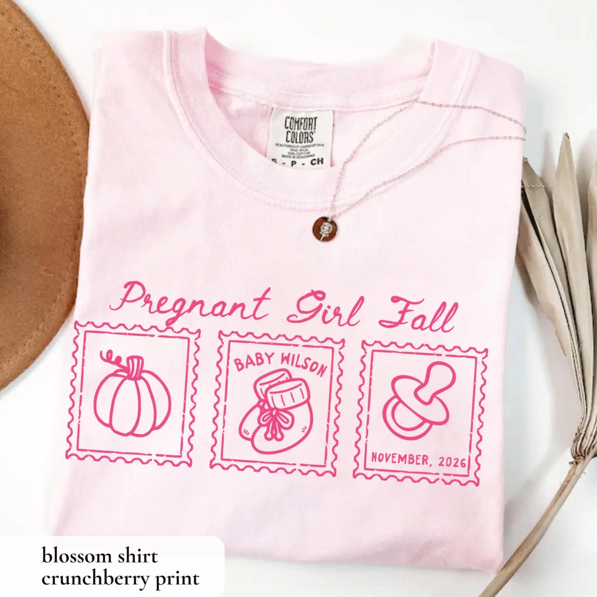 Folded Blossom pink Comfort Colors tee with hot pink pregnant girl fall script and pumpkin, bootie and pacifier stamps