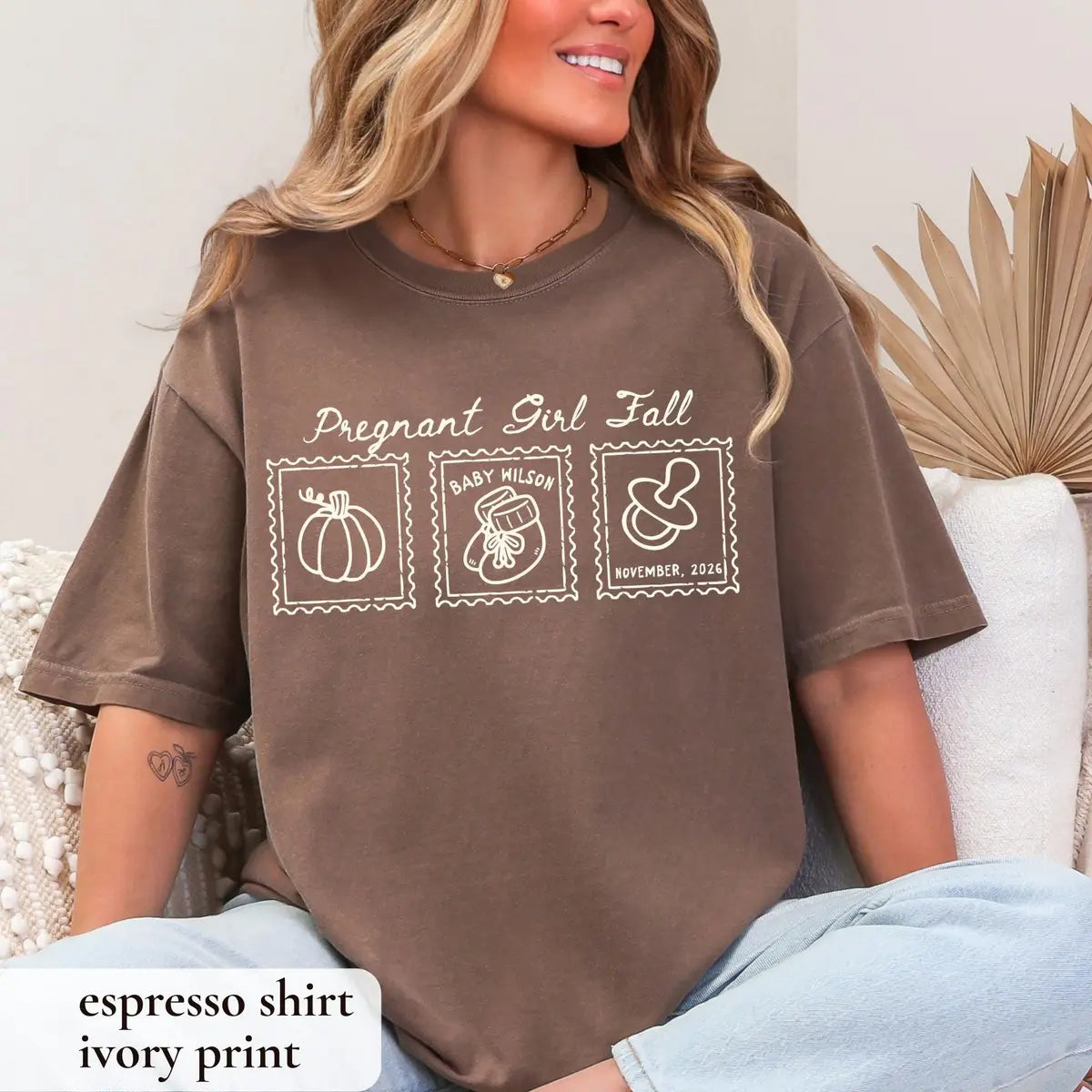 Woman in an Espresso brown Comfort Colors tee sitting on a couch, ivory pregnant girl fall script with three stamps