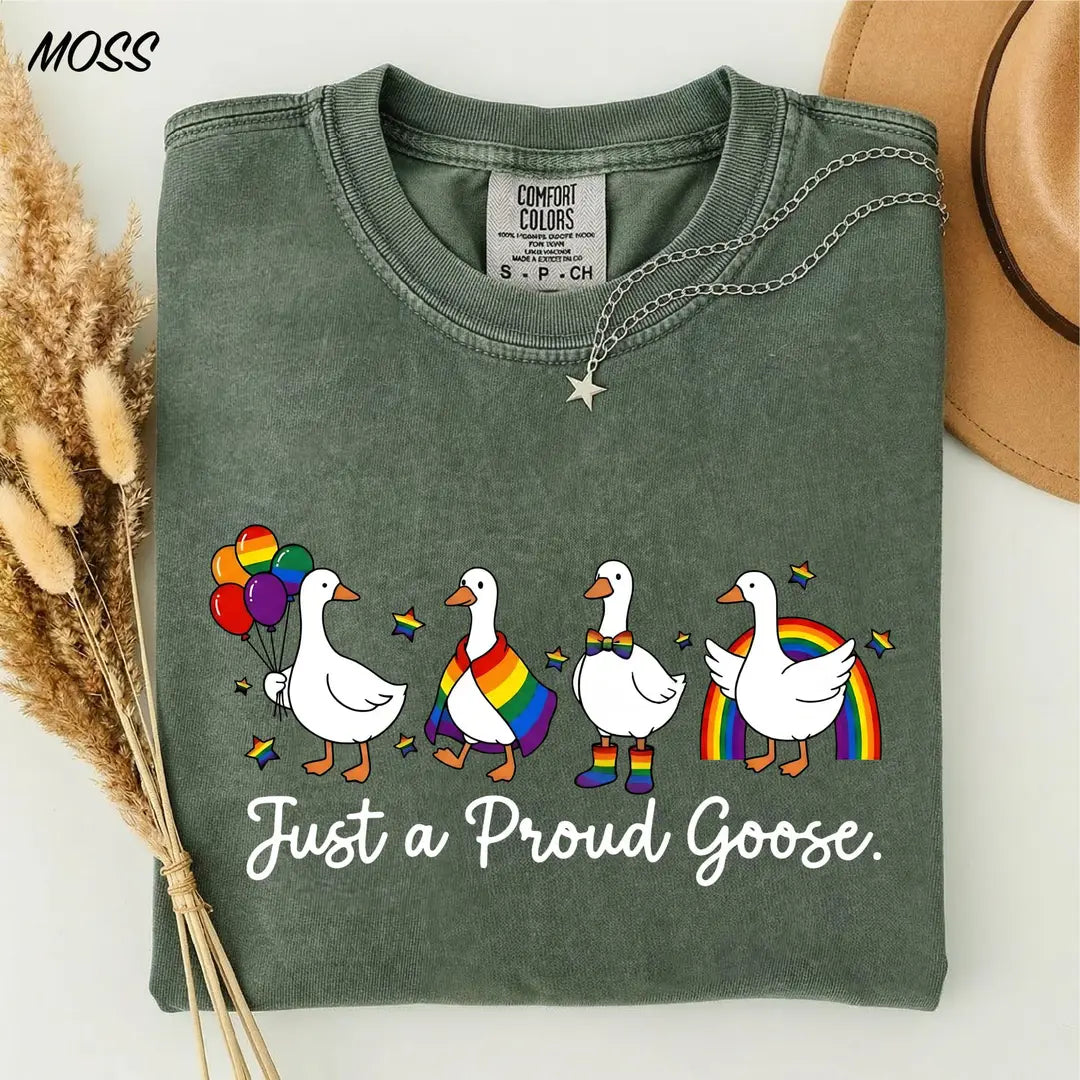 Moss Comfort Colors 1717 T-shirt with four geese in rainbow pride accessories and Just a Proud Goose lettering.