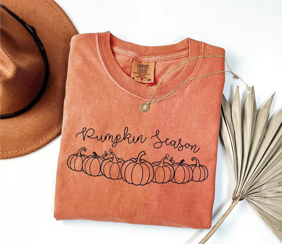 Yam orange Comfort Colors T-shirt with black Pumpkin Season script and outlined pumpkins.