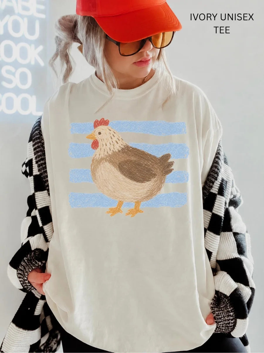 Woman in an Ivory Comfort Colors tee, red cap and checkered cardigan, with a brown hen on light blue stripes