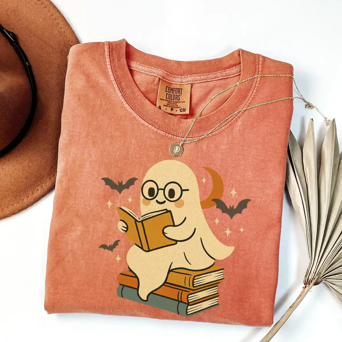 Black Comfort Colors T-shirt mockup showing Retro Ghost Reading Books Halloween design