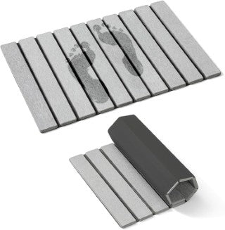 Gray foldable stone mat with a roller for cleaning purposes on a white background