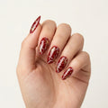 ruby red hand painted christmas almond press on nails snowflake gold swirl flat lay 03
