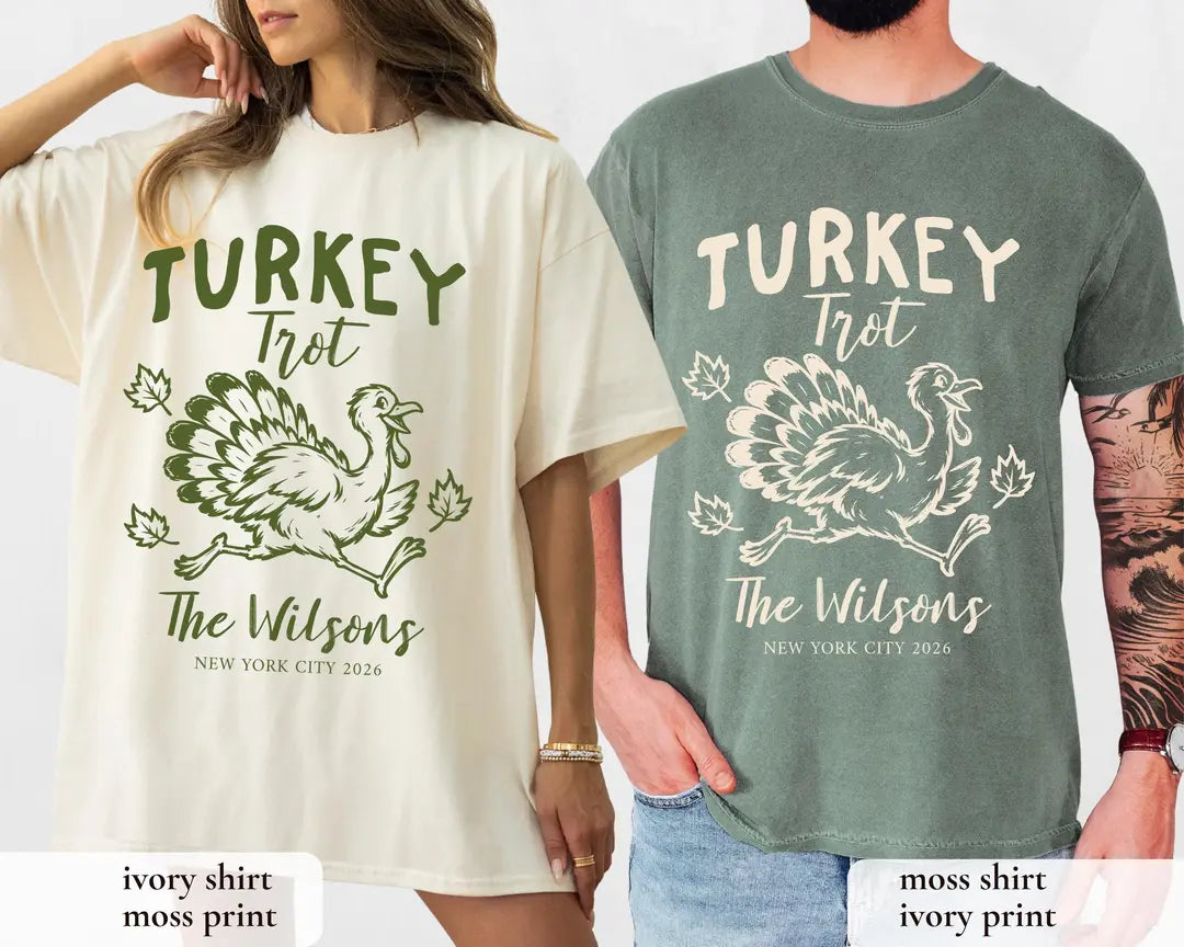 Woman and man in Ivory and Moss Comfort Colors tees, Turkey Trot with a running turkey, leaves and The Wilsons