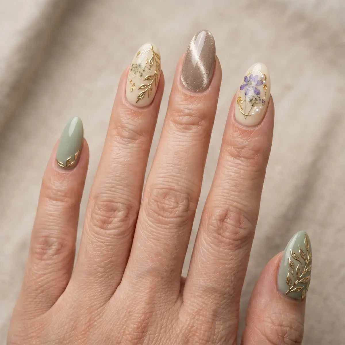 Hand with decorative nail art on a neutral background