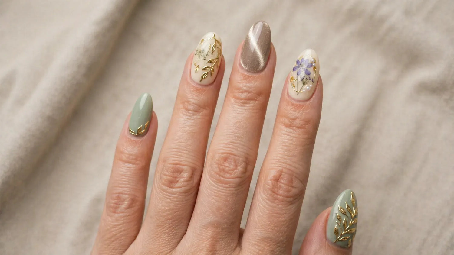 Hand with intricately designed nails on a neutral background