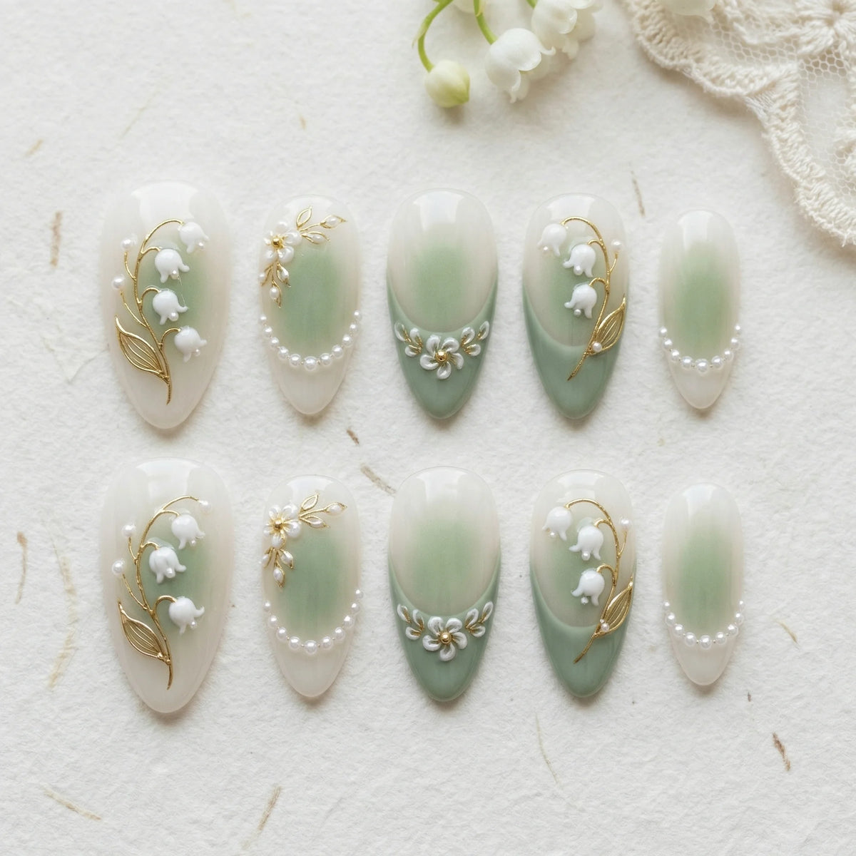 sage green hand painted almond medium press on nails lily of the valley flat lay 01