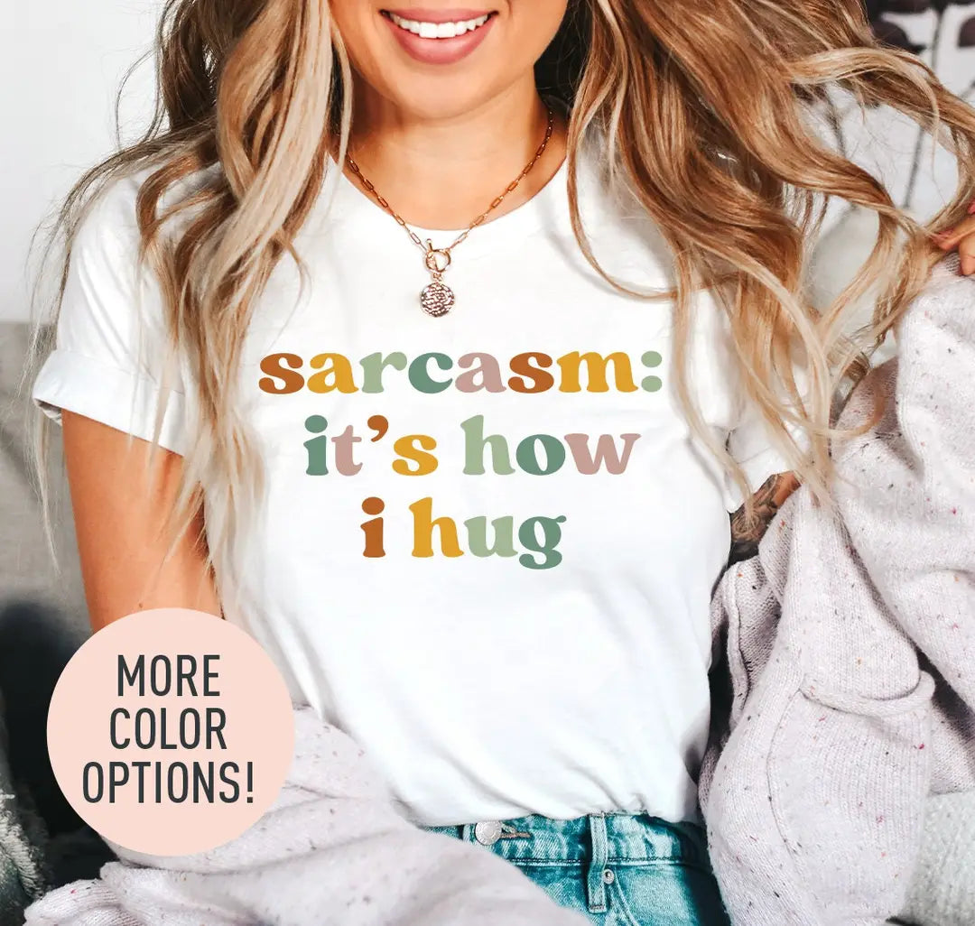 Woman in a white tee and a lilac cardigan, sarcasm: it's how i hug stacked in rust, sage and mustard retro lettering