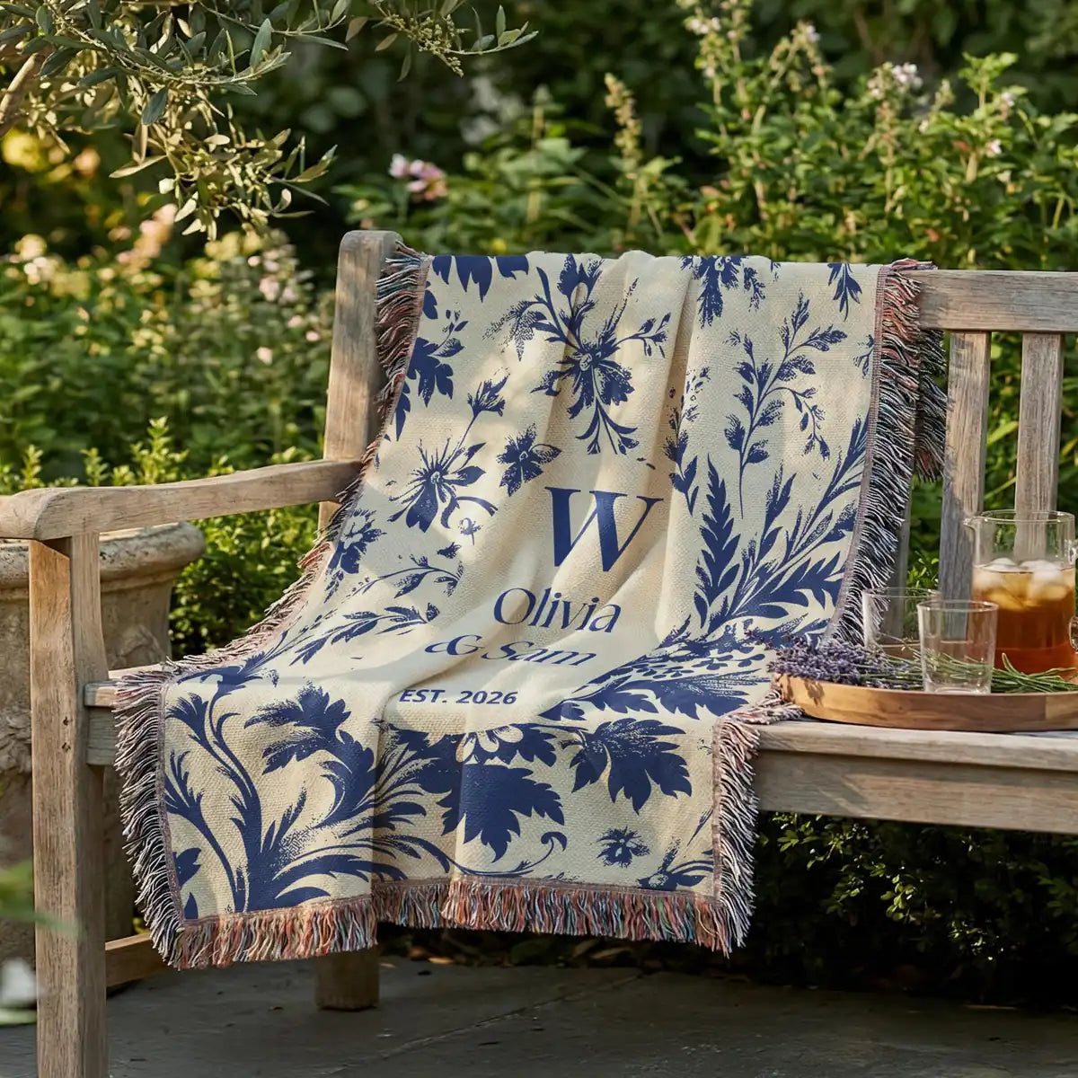 Close-up of the personalized scenic toile woven blanket with monogram and fringe detail
