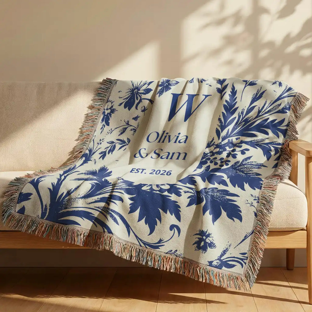 Close-up of the personalized scenic toile woven blanket with monogram and fringe detail