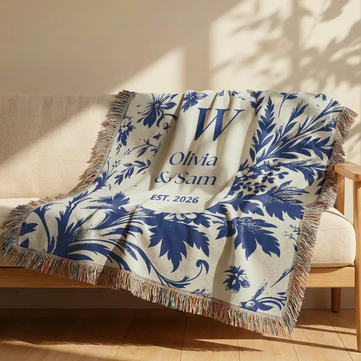 Close-up of the personalized scenic toile woven blanket with monogram and fringe detail