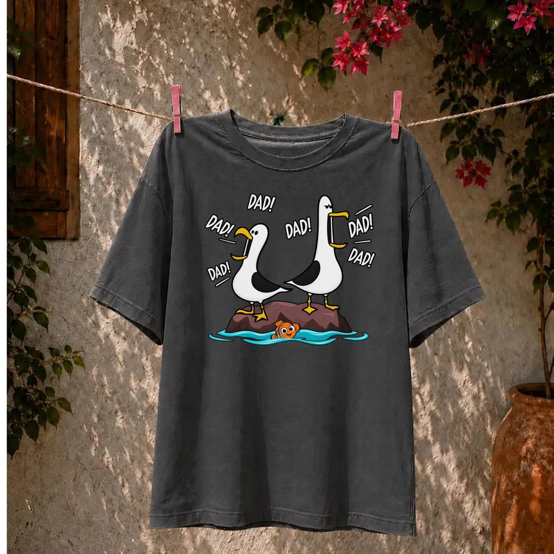 Pepper Comfort Colors tee hanging on a clothesline with two cartoon seagulls on a rock calling Dad in comic lettering