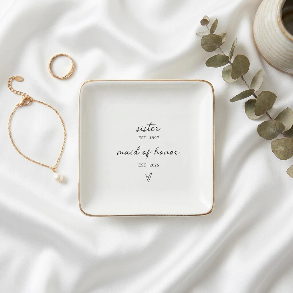 Round personalized maid of honor ring dish with gold rim on white satin