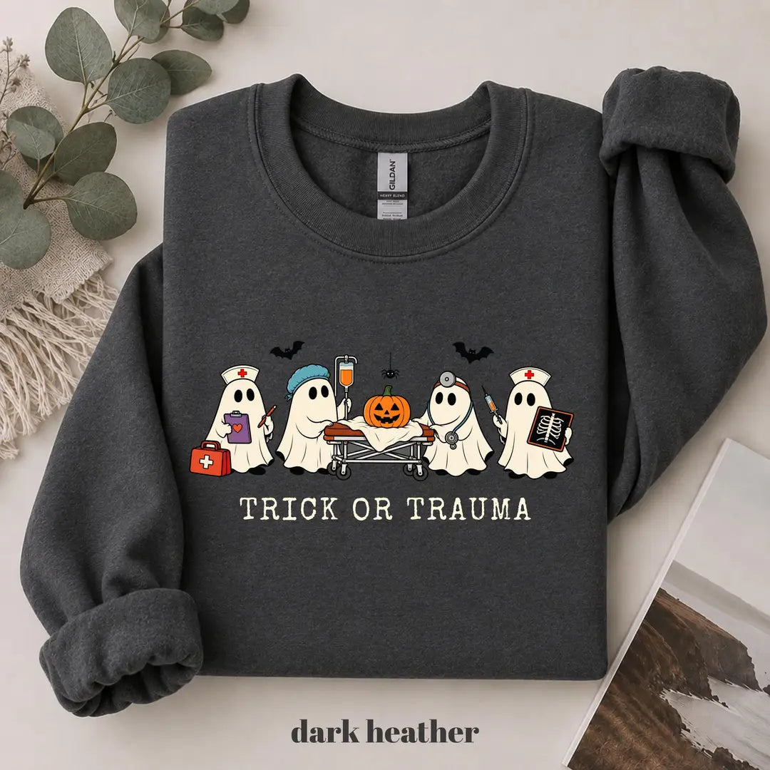 Dark Heather crewneck sweatshirt with printed nurse ghosts with a pumpkin and the words trick or trauma, flat lay view.