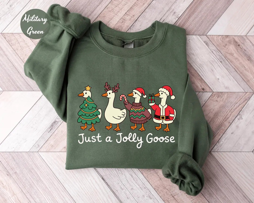 Military Green crewneck sweatshirt with geese dressed as a Christmas tree, reindeer and Santa above the words just a jolly goose, flat lay view.