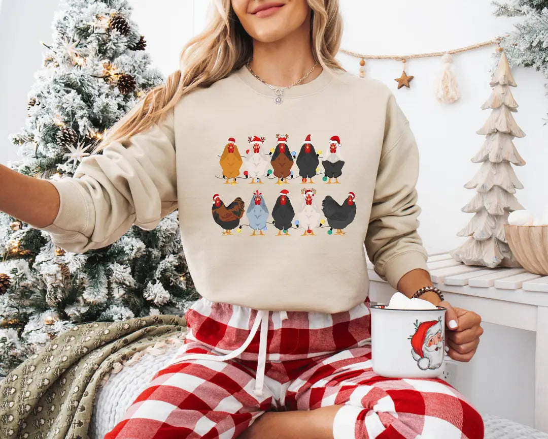 Sand crewneck sweatshirt with two rows of colorful chickens wearing Santa hats, worn by a model.