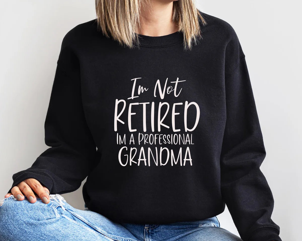 Black Crewneck sweatshirt with I'm Not Retired I'm A Professional Grandma design, alternate product view.