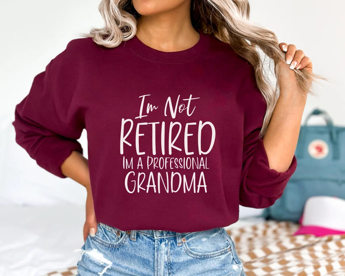 Maroon Crewneck sweatshirt with I'm Not Retired I'm A Professional Grandma design, alternate product view.