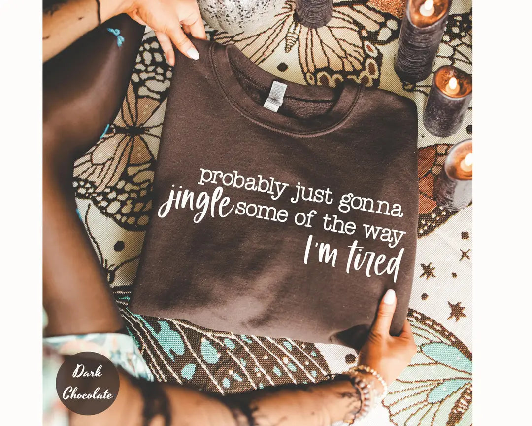 Dark Chocolate crewneck sweatshirt with script lettering that reads probably just gonna jingle some of the way I'm tired, flat lay view.