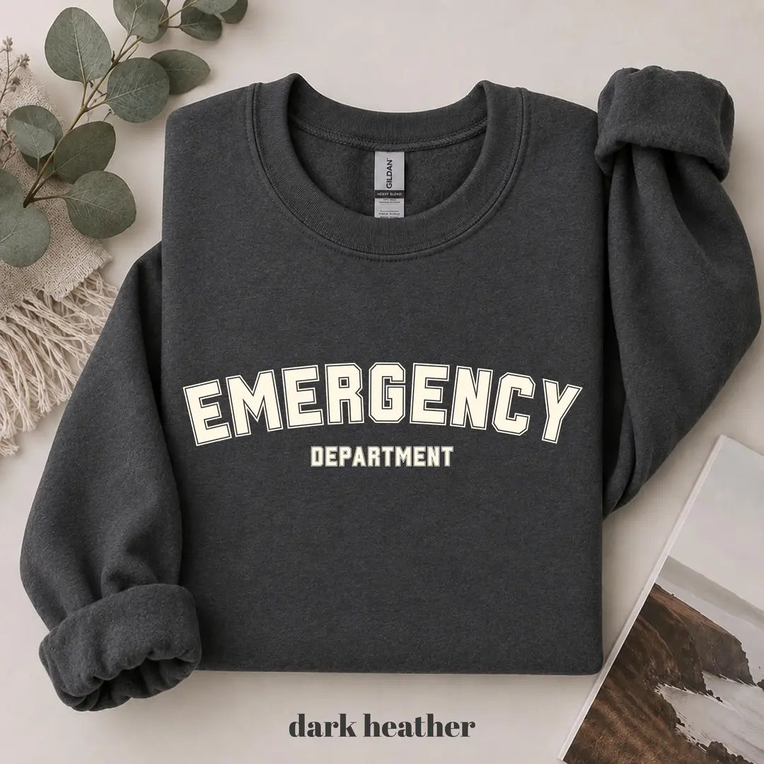 Dark Heather crewneck sweatshirt with printed varsity style emergency department lettering, flat lay view.