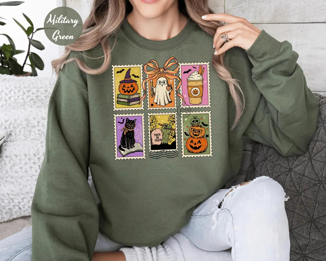 Military Green crewneck sweatshirt with six vintage postage-style stamps with a ghost, black cat, pumpkins and a coffee cup, worn by a model.