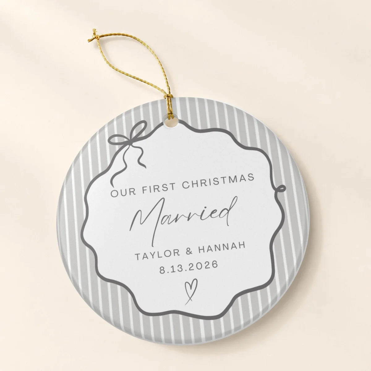 Gray pinstripe round ceramic First Christmas Married ornament with a bow frame, personalized names and date, and a gold hanging string