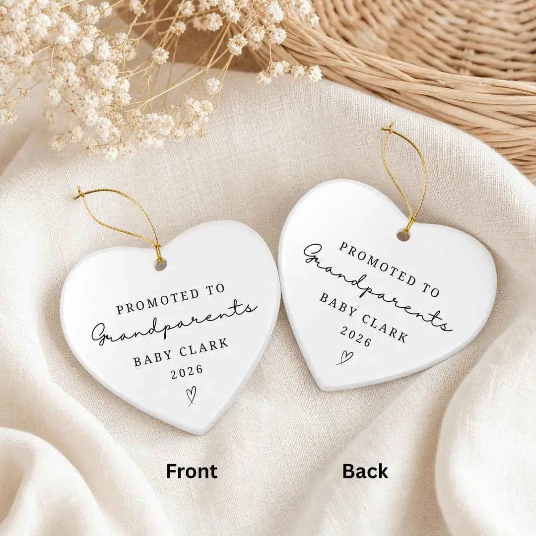 Front and back of a heart-shaped white ceramic Promoted to Grandparents ornament with the same personalized baby name and year on both sides