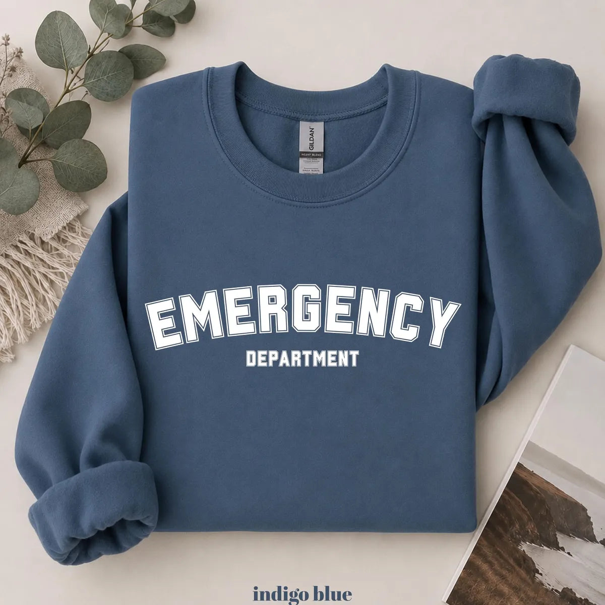 Indigo Blue crewneck sweatshirt with printed varsity style emergency department lettering, flat lay view.