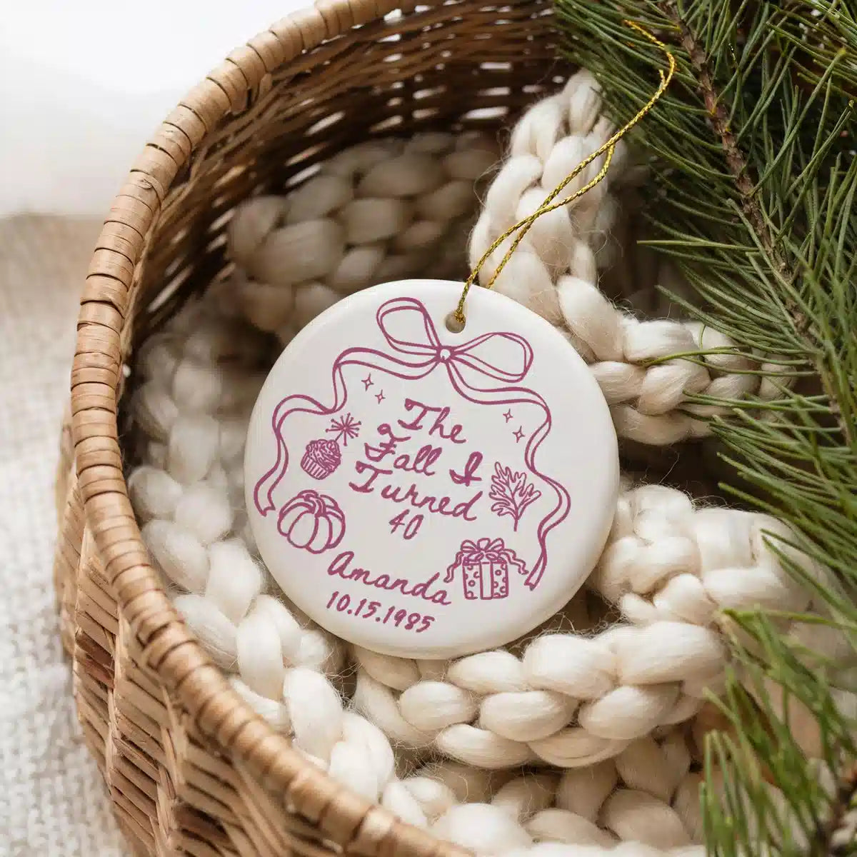 Personalized The Fall I Turned 40 ceramic ornament shown in a basket lifestyle scene.