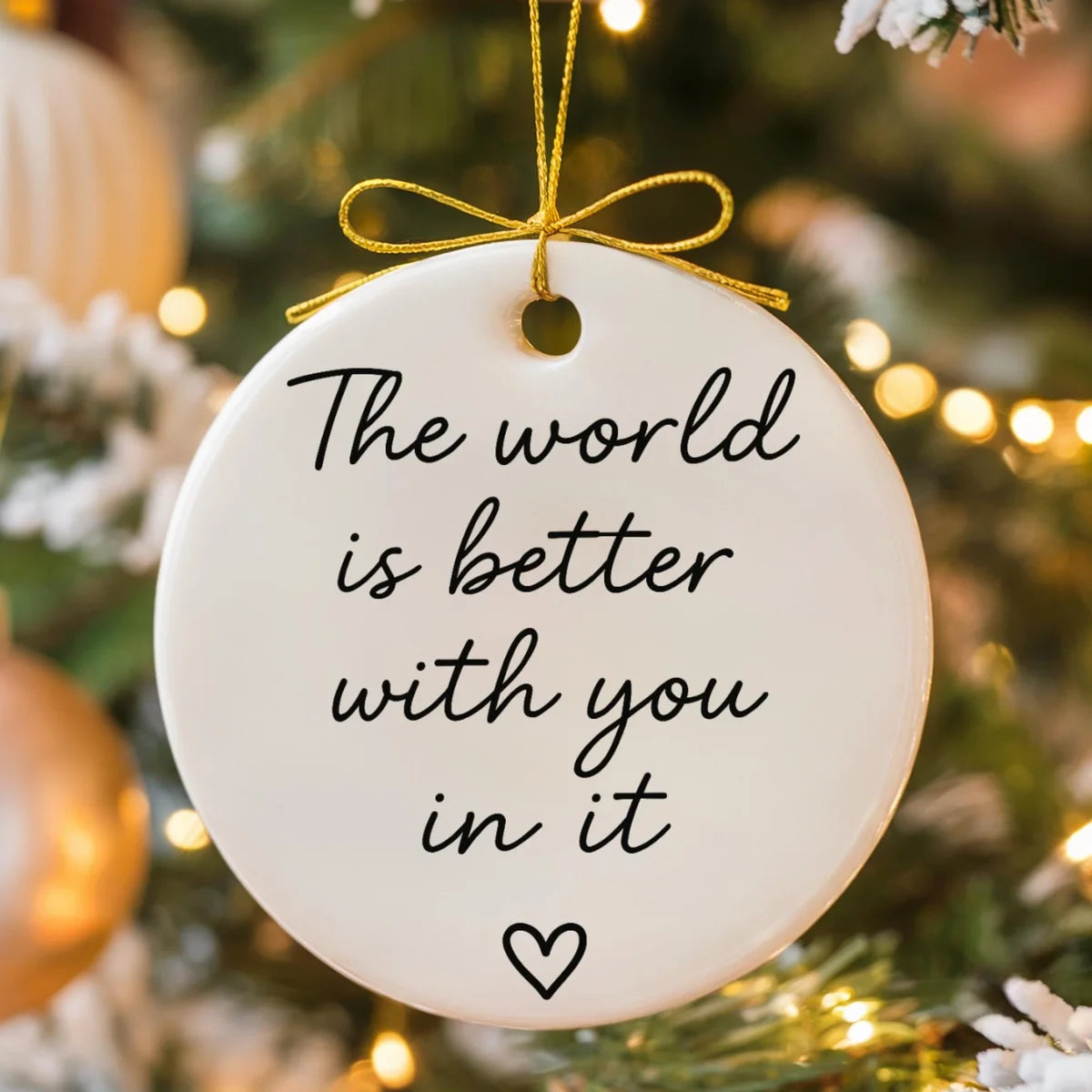 Alternate view of a round ceramic ornament with the visible The World Is Better With You in It message.