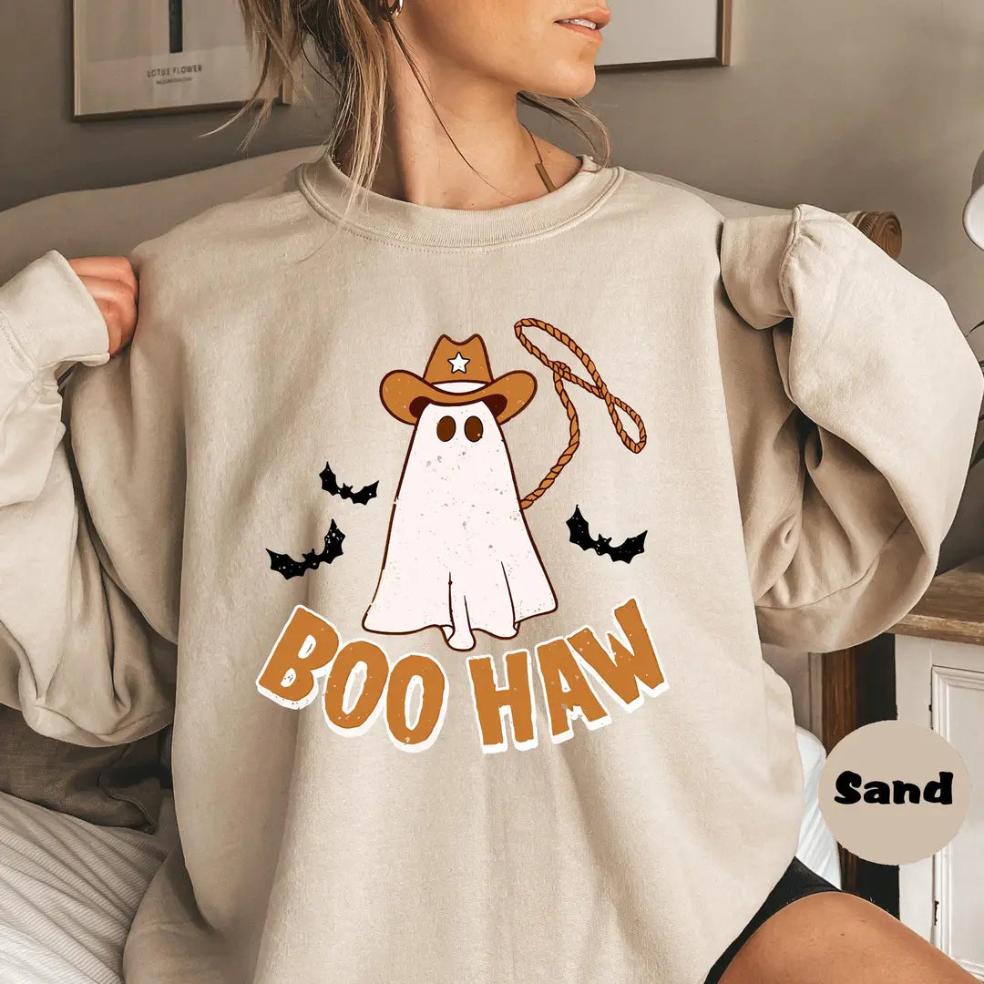 Sand crewneck sweatshirt with a cowboy ghost with a lasso and bats above the words boo haw, worn by a model.