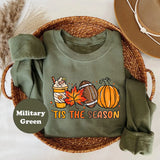 Military Green crewneck sweatshirt with a latte, autumn leaves, a football and a pumpkin above the words tis the season, flat lay view.