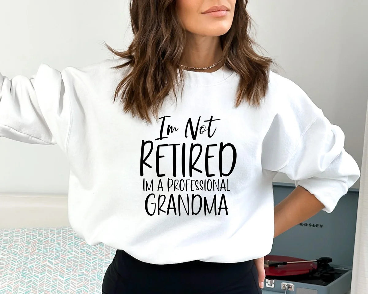 White Crewneck sweatshirt with I'm Not Retired I'm A Professional Grandma design, alternate product view.