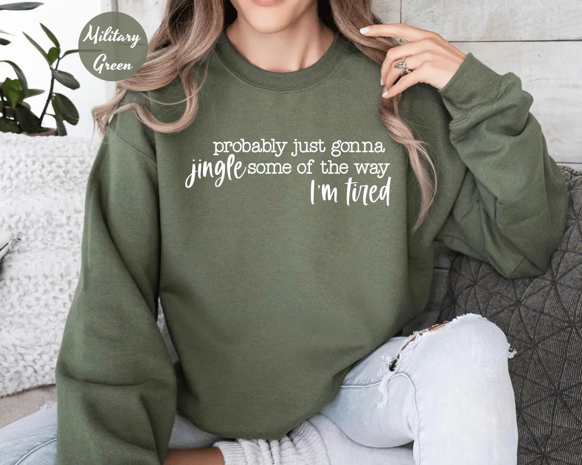 Military Green crewneck sweatshirt with script lettering that reads probably just gonna jingle some of the way I'm tired, worn by a model.