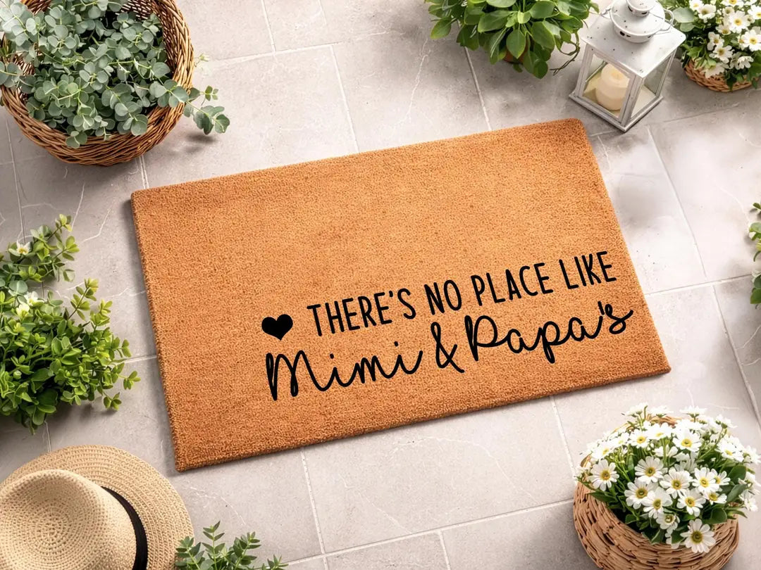 Coir doormat with a There's No Place Like Mimi and Papa's message on pale tile with a straw hat, flower baskets, and a lantern