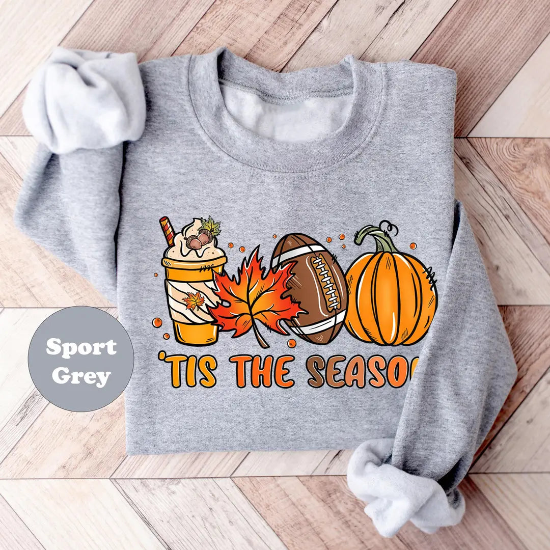 Sport Grey crewneck sweatshirt with a latte, autumn leaves, a football and a pumpkin above the words tis the season, flat lay view.