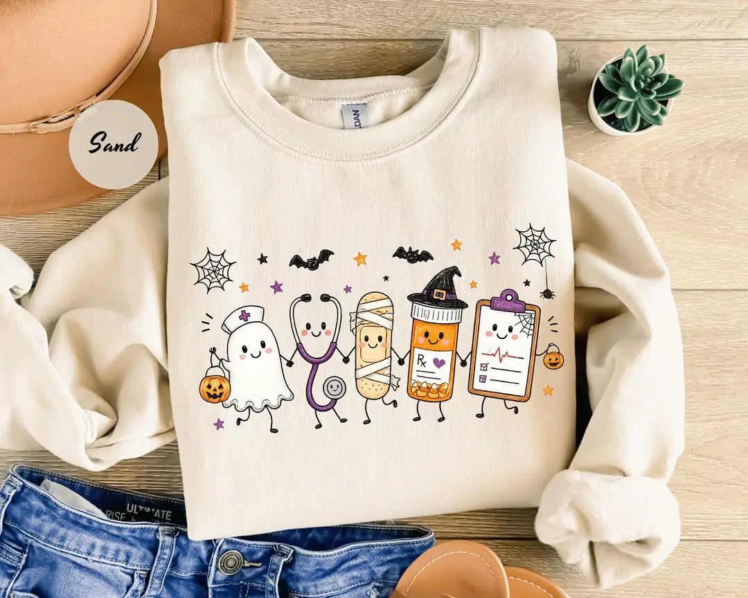 Sand crewneck sweatshirt with a ghost, stethoscope, bandage and medical chart characters with Halloween details, flat lay view.