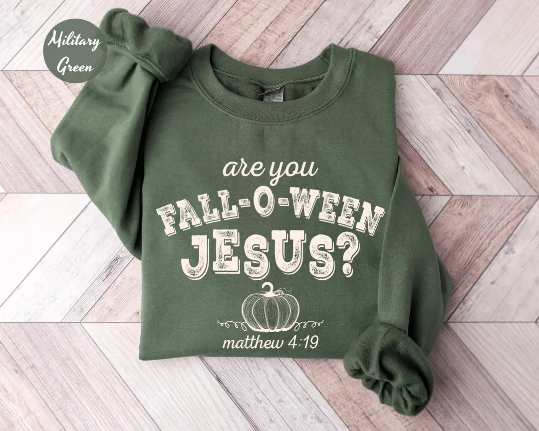 Military Green crewneck sweatshirt with printed a pumpkin with the words are you fall-o-ween jesus and matthew 4:19 in a western style font, flat lay view.