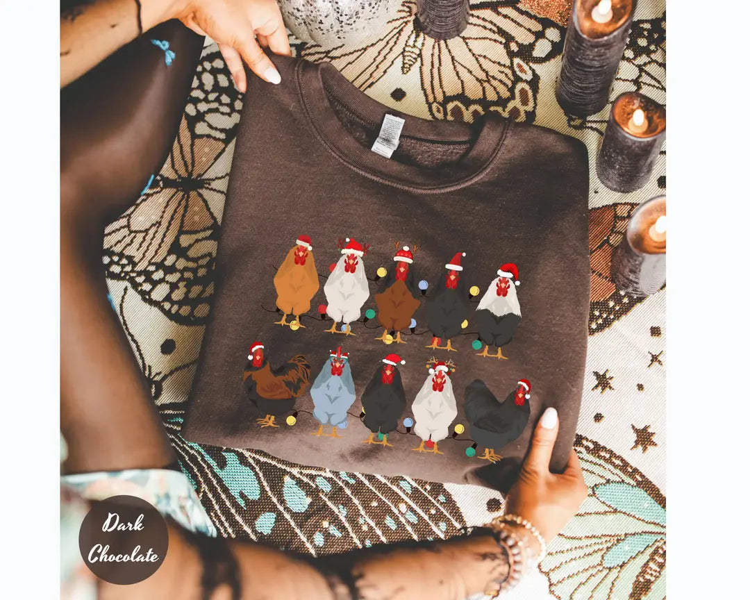 Dark Chocolate crewneck sweatshirt with two rows of colorful chickens wearing Santa hats, flat lay view.