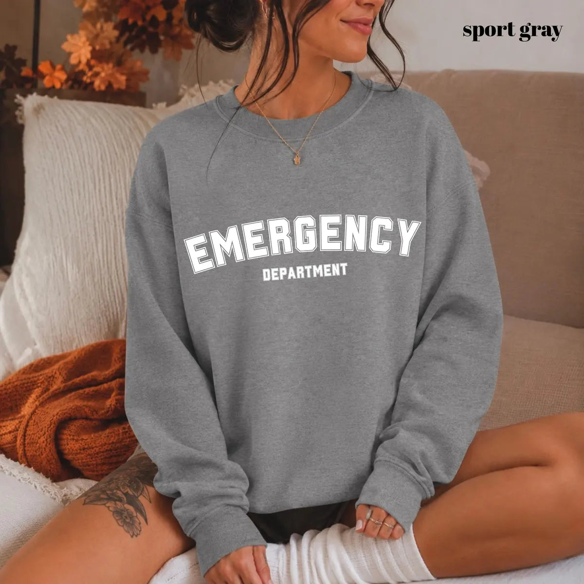 Sport Grey crewneck sweatshirt with printed varsity style emergency department lettering, worn by a model.