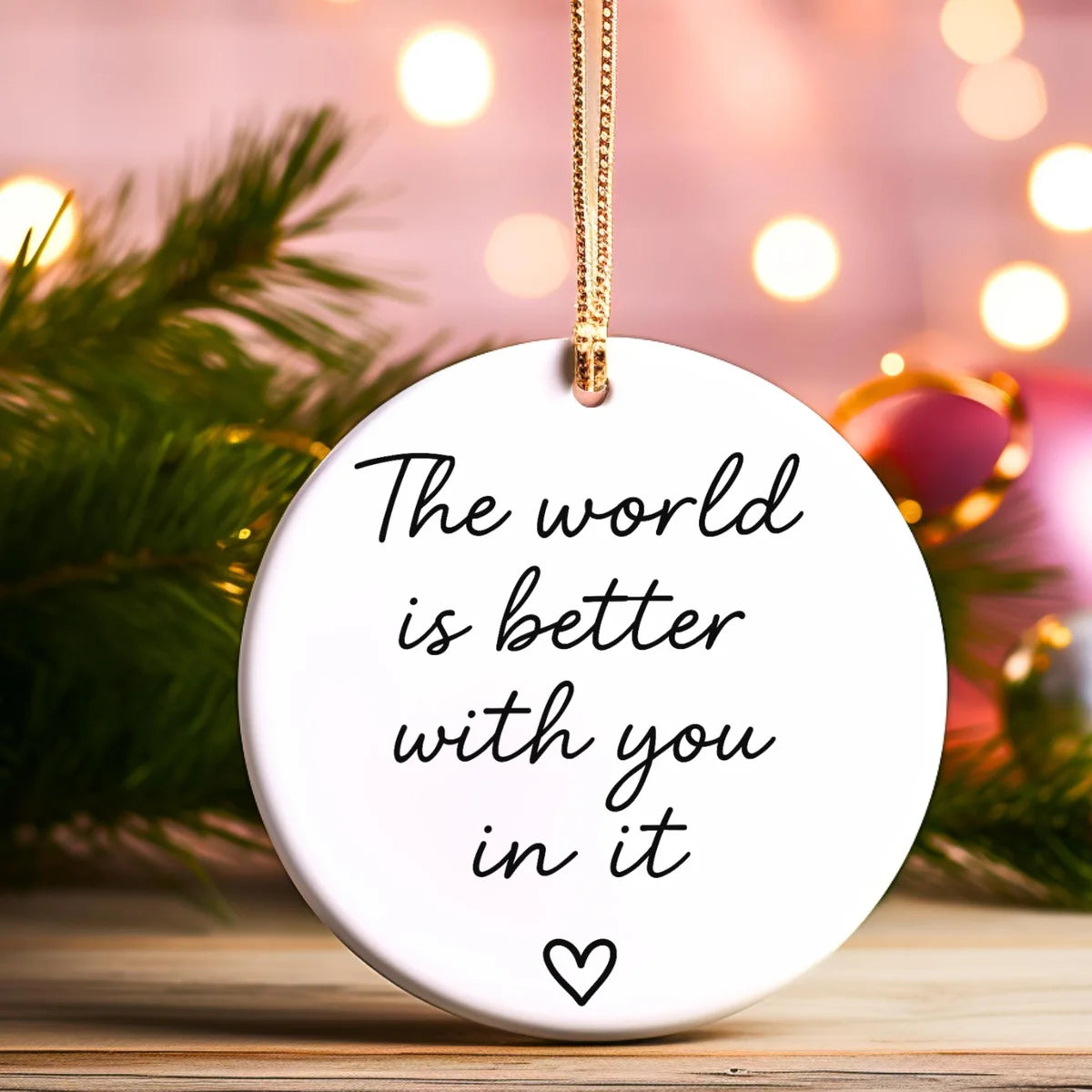 Alternate view of a round ceramic ornament with the visible The World Is Better With You in It message.