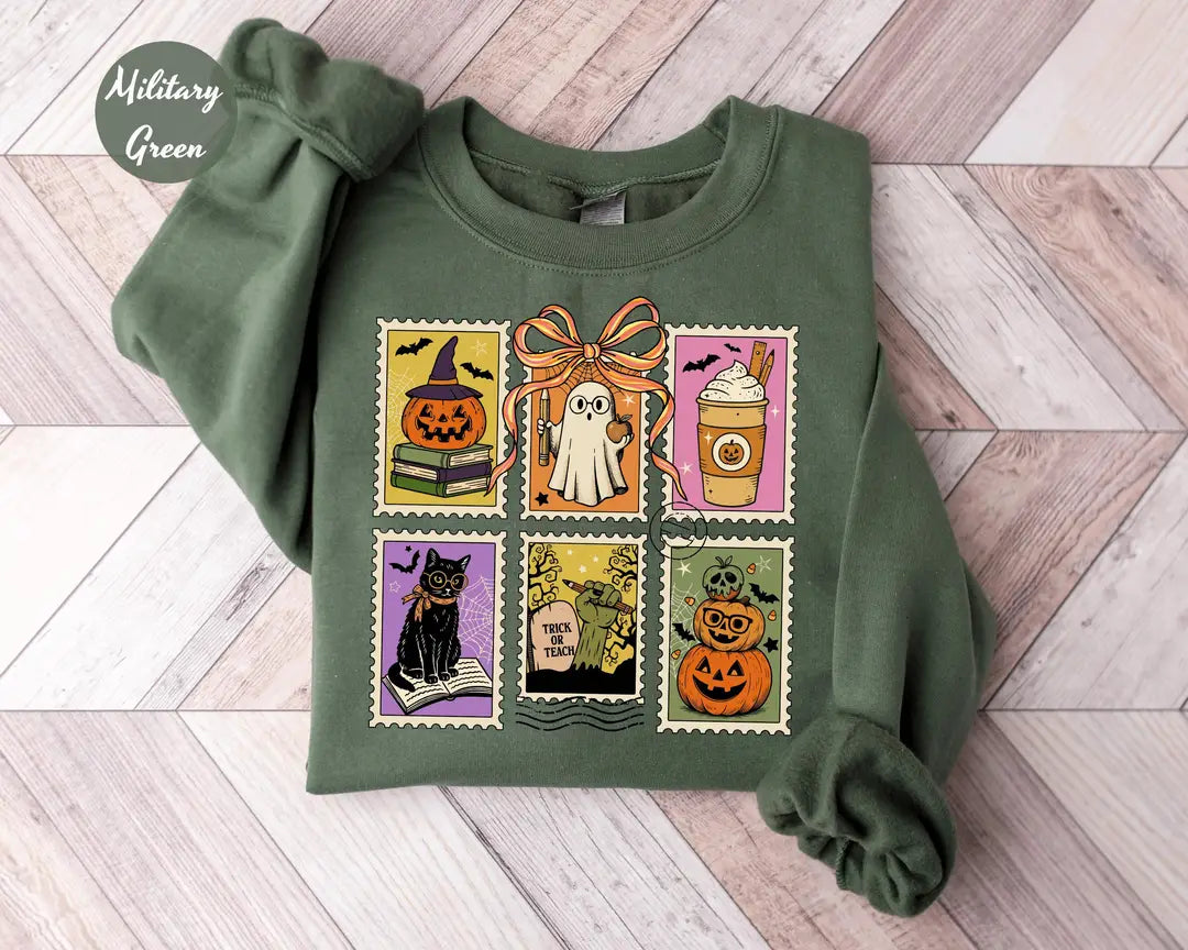Military Green crewneck sweatshirt with six vintage postage-style stamps with a ghost, black cat, pumpkins and a coffee cup, flat lay view.