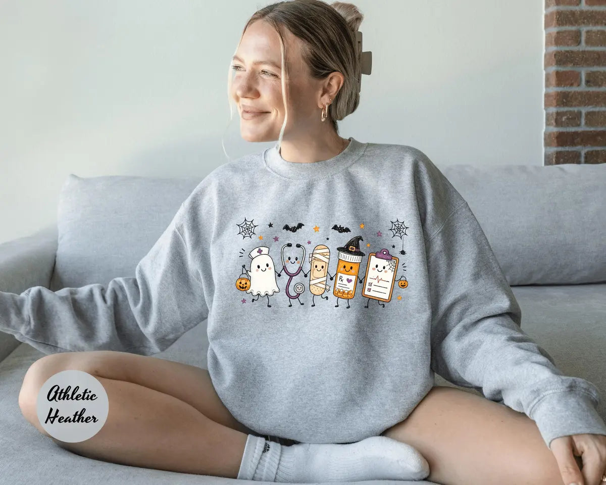 Athletic Heather crewneck sweatshirt with a ghost, stethoscope, bandage and medical chart characters with Halloween details, worn by a model.