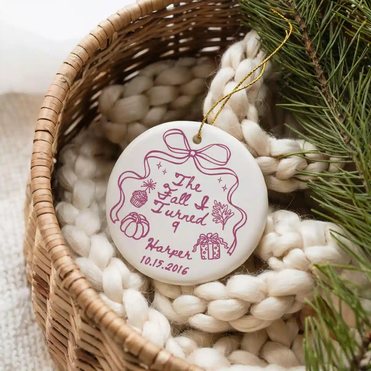 Personalized ceramic ornament featuring Fall I Turned 9 shown in a basket lifestyle scene.