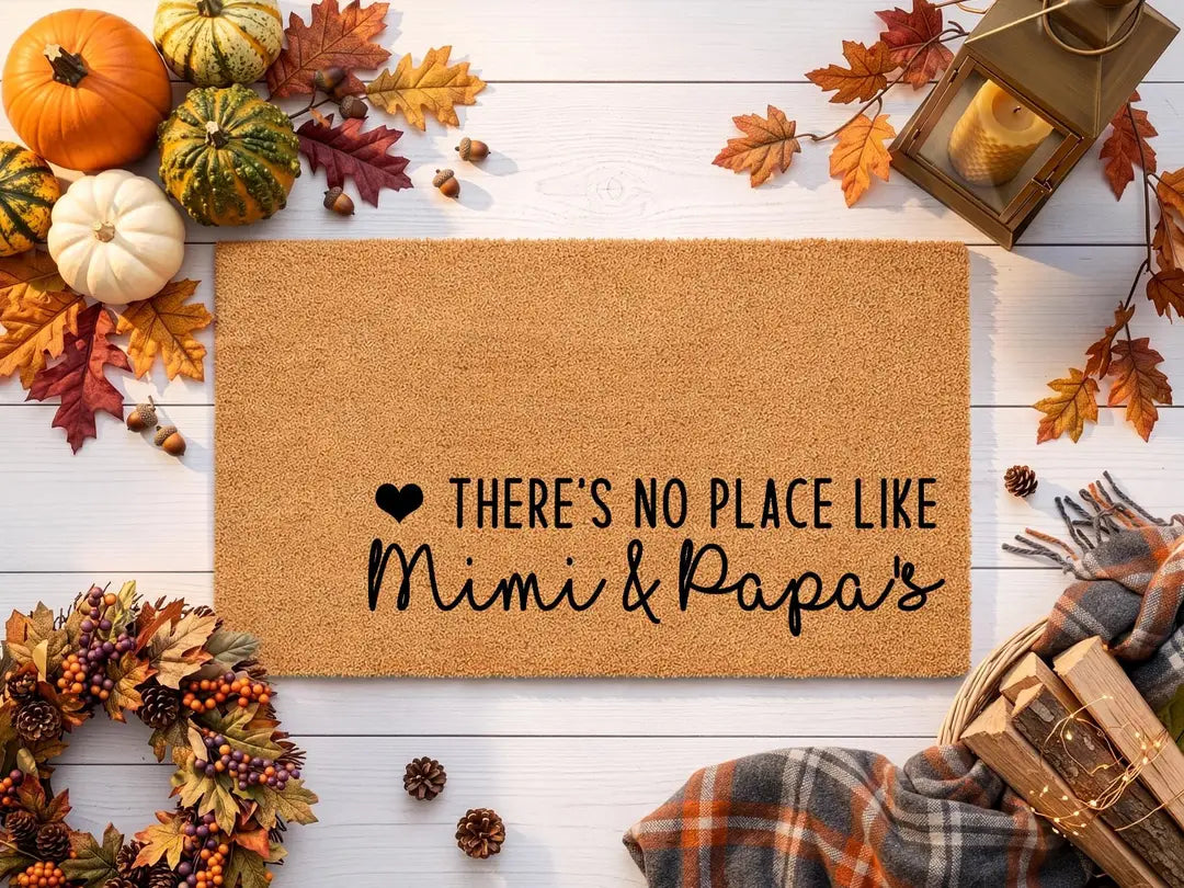 Coir doormat with a There's No Place Like Mimi and Papa's message styled with pumpkins, autumn leaves, a plaid blanket, and a lantern